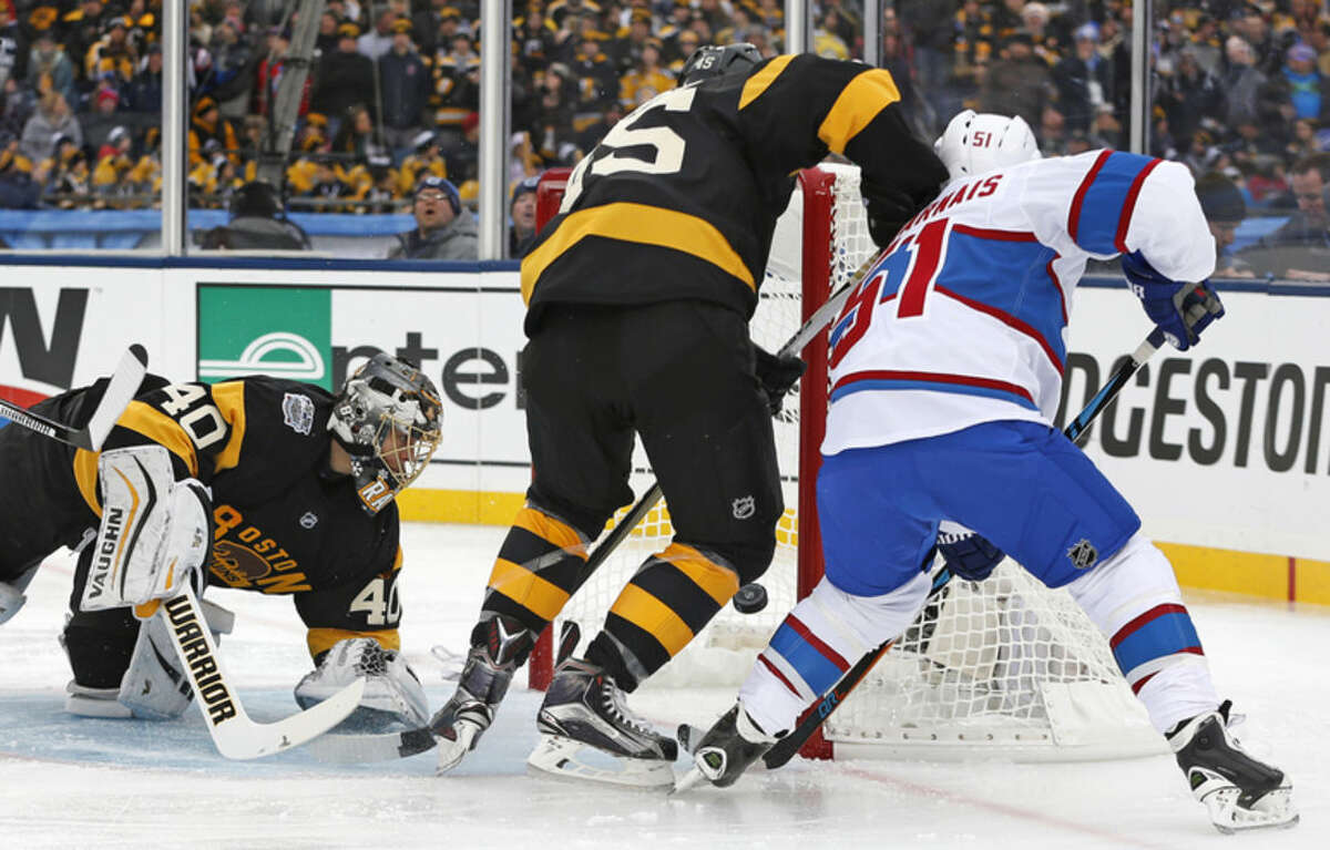 Montreal Canadiens center David Desharnais (51) pokes the puck past Boston Bruins goalie Tuukka Rask (40) for a goal during the first period of the NHL Winter Classic hockey game at Gillette Stadium in Foxborough, Mass., Friday, Jan. 1, 2016. At center is Bruins defenseman Joe Morrow (45). (AP Photo/Michael Dwyer)