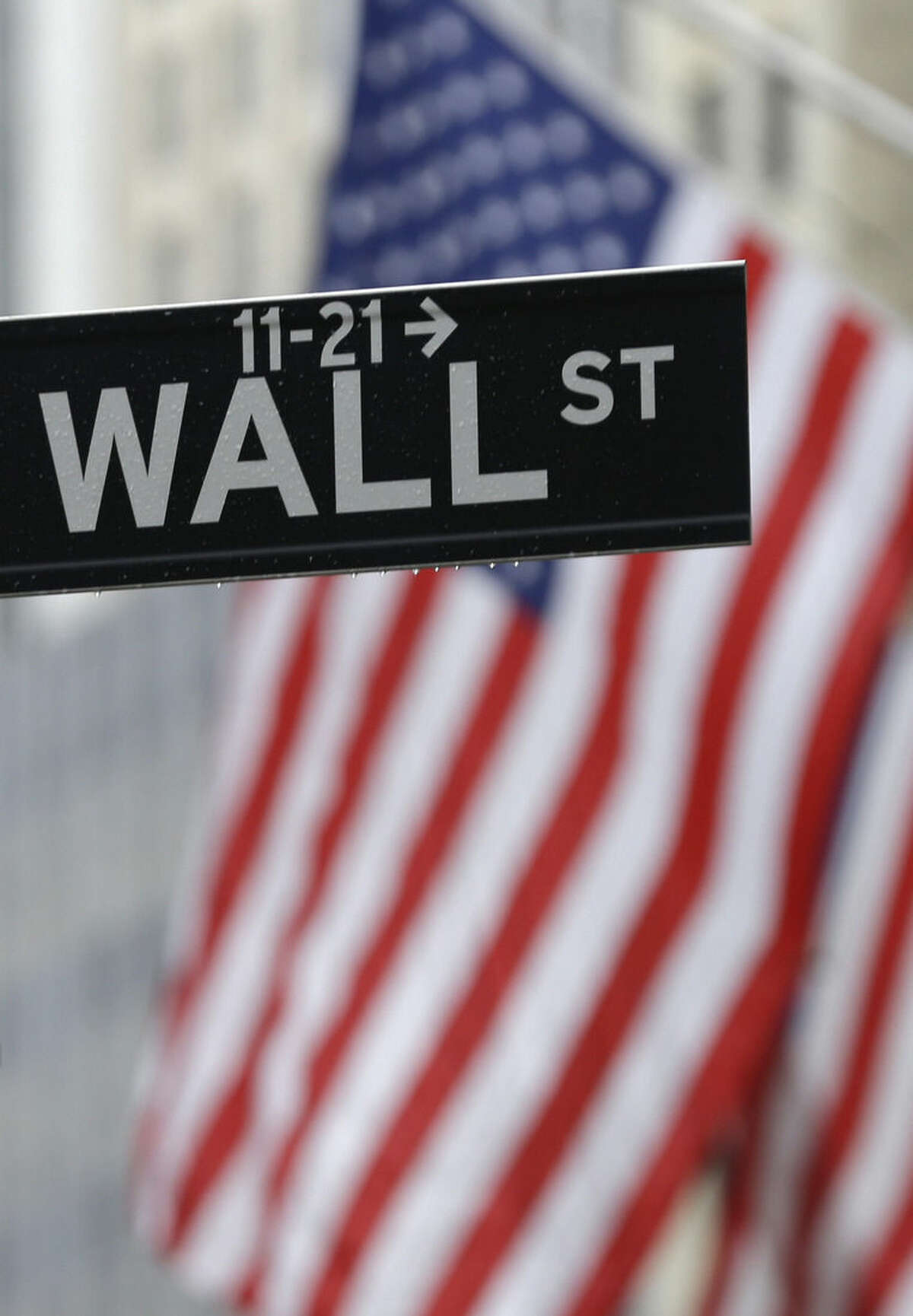 FILE - In this July 9, 2015 file photo, a Wall Street sign is seen near the New York Stock Exchange in New York. U.S. stocks moved lower on the last day of the year as the market headed for a sluggish end to 2015. (AP Photo/Seth Wenig, File)