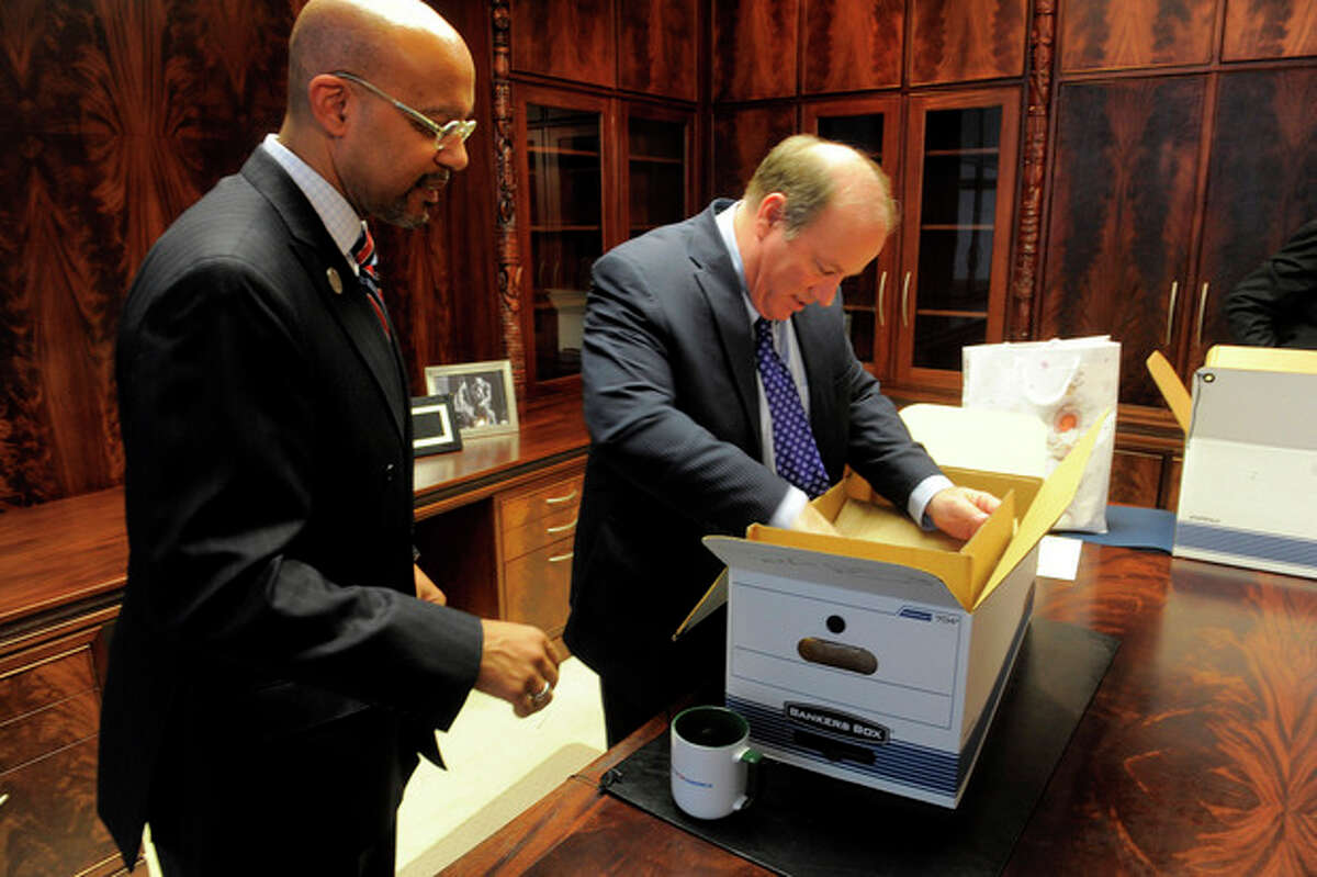 New Detroit Mayor Mike Duggan unpacks boxes with Melvin "Butch" Hollowell after taking the oath of office, New Years Day, Wednesday, Jan. 1, 2014, at the Coleman Young Municipal Center in Detroit. (AP Photo/The Detroit News, Steve Perez)