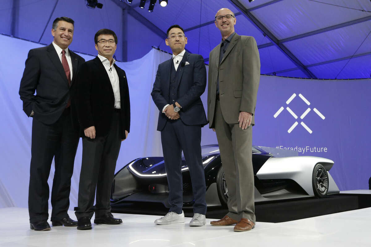 Nevada Gov. Brian Sandoval, left, poses for a photo in front of the FFZero1 by Faraday Future, alongside members of the Faraday Future team at CES Unveiled, a media preview event for CES International Monday, Jan. 4, 2016, in Las Vegas. The high-performance electric concept car was unveiled during a news conference by Faraday Future. From right are Nick Sampson, product developer, Richard Kim, head of global design, Ding Lei, and letv co-founder. (AP Photo/Gregory Bull)