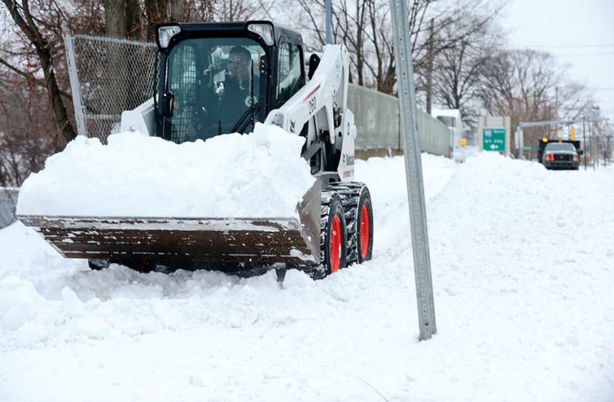 Hour photo / Erik Trautmann Norwalk Department of Public Works clears sidewalk on East Ave after snowstorm Hercules dumped 6" of snow on the area Friday.