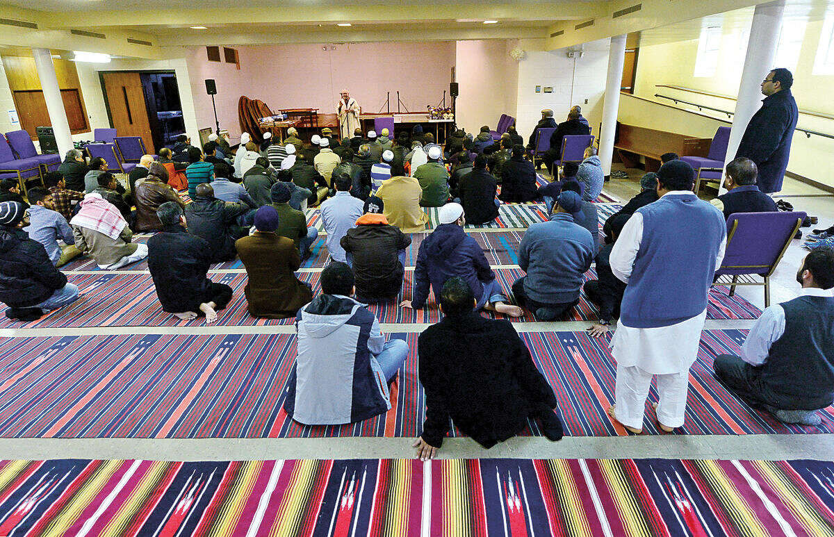 Hour photo / Erik Trautmann Muslims worship at the new home of the Al Madany mosque on Park St in Norwalk Friday.