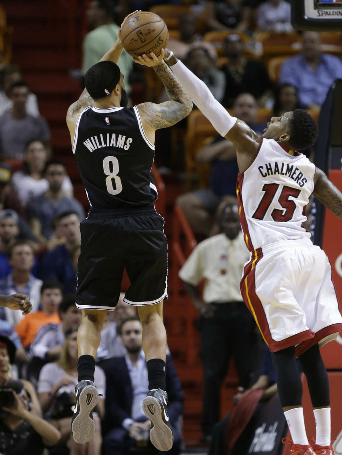 Brooklyn Nets guard Deron Williams (8) shoots over Miami Heat guard Mario Chalmers (15) during the first half of an NBA basketball game, Sunday, Jan. 4, 2015, in Miami. (AP Photo/Lynne Sladky)