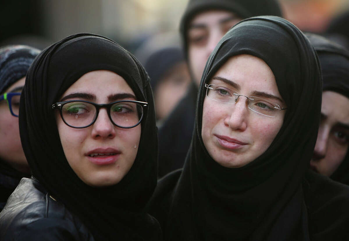 Sisiters of Ali Khadra, who was killed Thursday by a car bomb explosion, weep as they attend their brother's funeral procession in the southern suburb of Beirut, Lebanon, Saturday, Jan. 4, 2014. An explosion tore through a crowded commercial street Thursday in a south Beirut neighborhood that is bastion of support for the Shiite group Hezbollah, killing several people, setting cars ablaze and sending a column of black smoke above the Beirut skyline. (AP Photo/Hussein Malla)