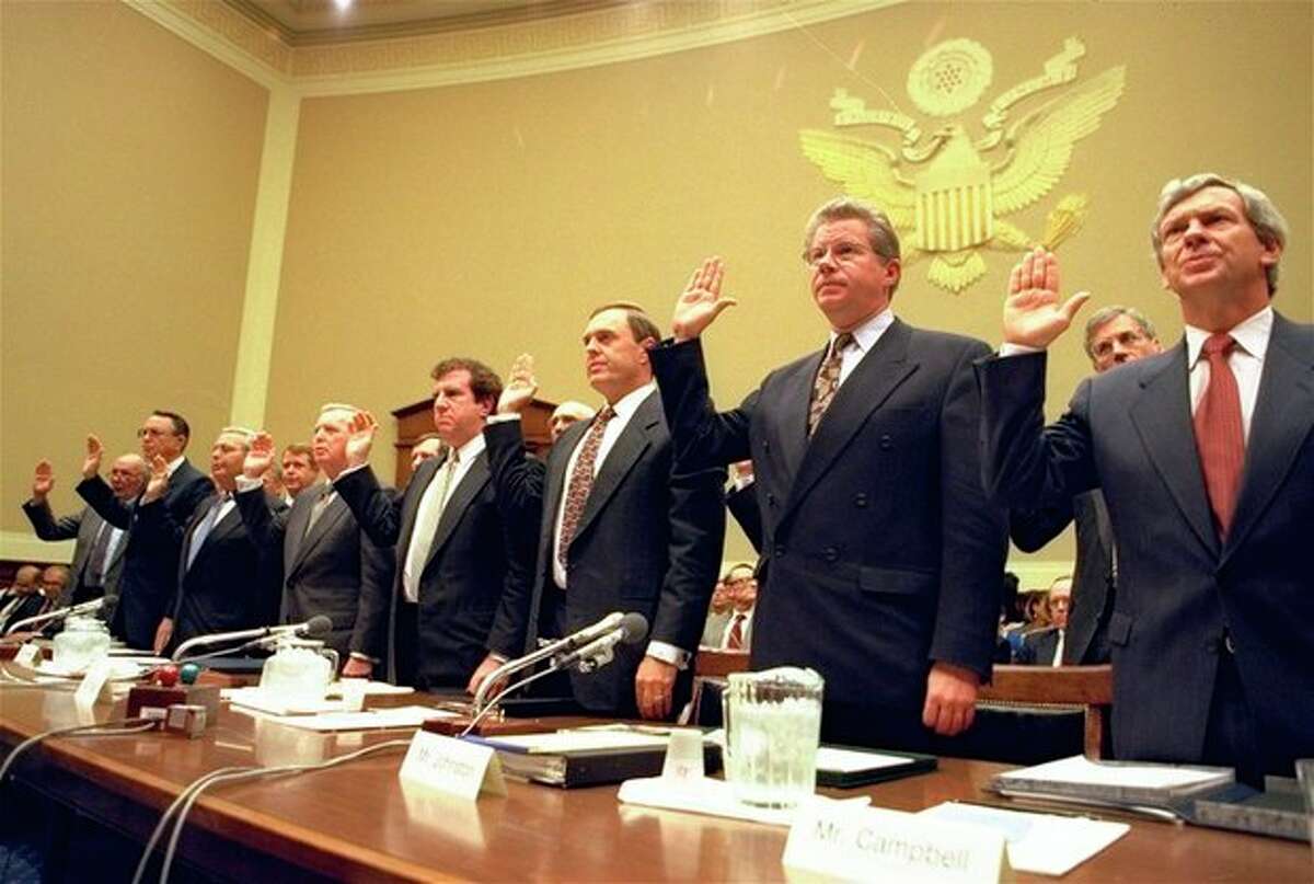 ADVANCE FOR USE SUNDAY, JAN. 5, 2014 AND THEREAFTER - FILE - In this Thursday, April 14, 1994 file photo, heads of the nation's largest cigarette companies are sworn in before a hearing of a House Energy subcommittee which was holding hearings on the contents of cigarettes on Capitol Hill in Washington. More than 40 states brought lawsuits demanding compensation for the costs of treating smoking-related illnesses. Big Tobacco settled in 1998 by agreeing to pay about $200 billion and curtail marketing of cigarettes to youths. From left are Robert Sprinkle III, executive vice president for Research American Tobacco Co.; Donald Johnston, American Tobacco; Thomas Sandefur Jr., Brown and Williamson Tobacco Corp.; Edward Horrigan Jr., Liggett Group Inc.; Andrews Tisch, Lorillard Tobacco Co.; Joseph Taddeo, U.S. Tobacco Co.; James Johnston, RJ Reynolds; and William Campbell, Phillip Morris USA. (AP Photo/John Duricka)