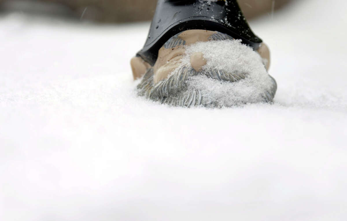 A garden gnome sits up to its chin in snow Sunday, Jan. 5, 2014, in St. Louis. Snow that began in parts of Missouri Saturday night picked up intensity after dawn Sunday with several inches of snow on the ground by midmorning and more on the way. (AP Photo/Jeff Roberson)