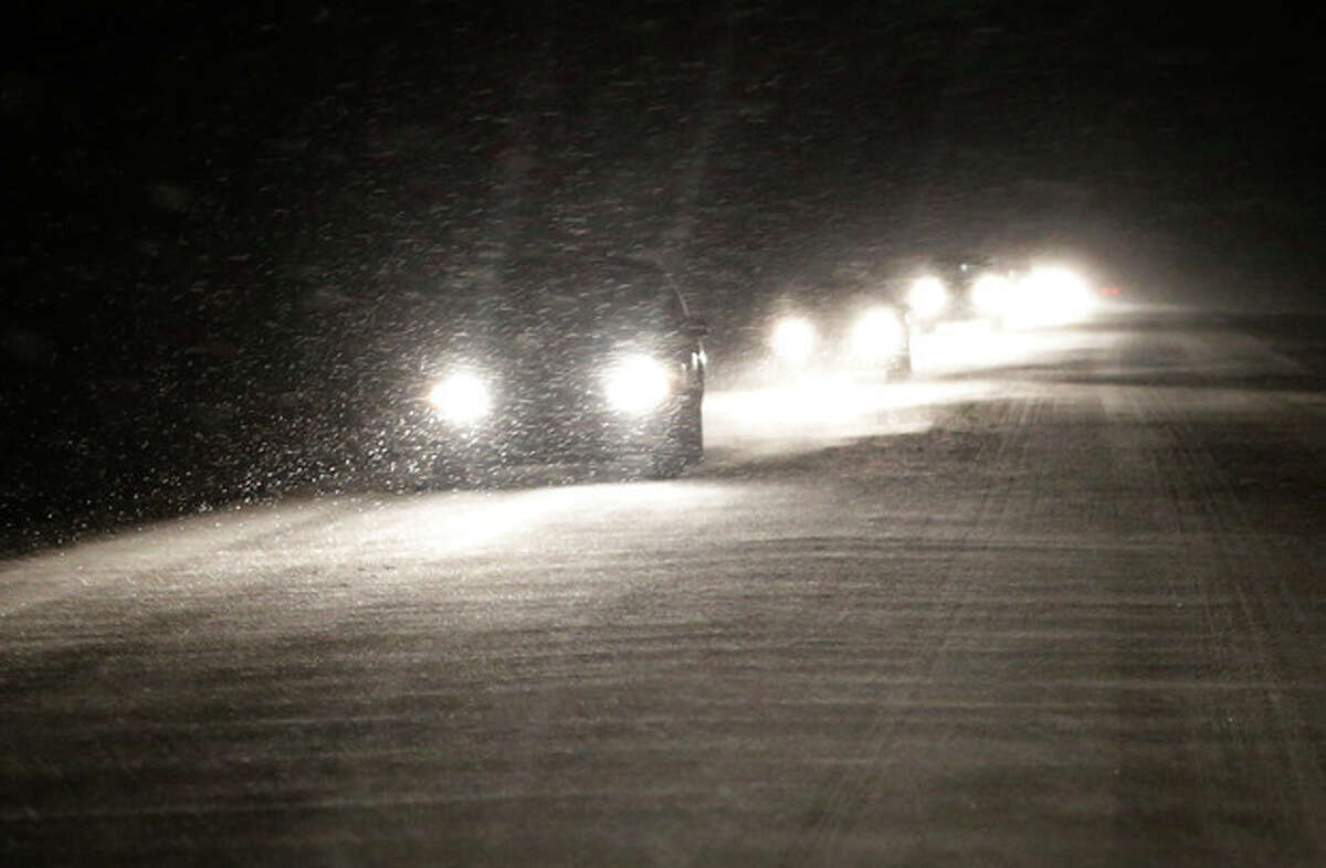 Motorists make there way west as snow begins to build up on US 24 near Belvue, Kan., Saturday, Jan. 4, 2014. The area is under a winter weather advisory and wind chill warning. (AP Photo/Orlin Wagner)