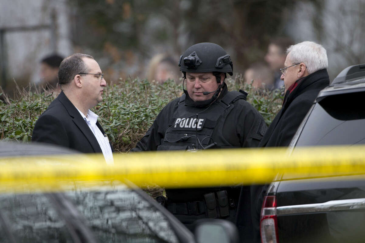 Law enforcement standby as investigators work the scene at one of the residences where suspect Edward Archer has lived Friday, Jan. 8, 2016, in Yeadon, Pa. Archer accused of ambushing a police officer and firing shots at point-blank range said he was acting in the name of Islam and had pledged allegiance to the Islamic State group, Philadelphia authorities said Friday. (AP Photo/Matt Rourke)
