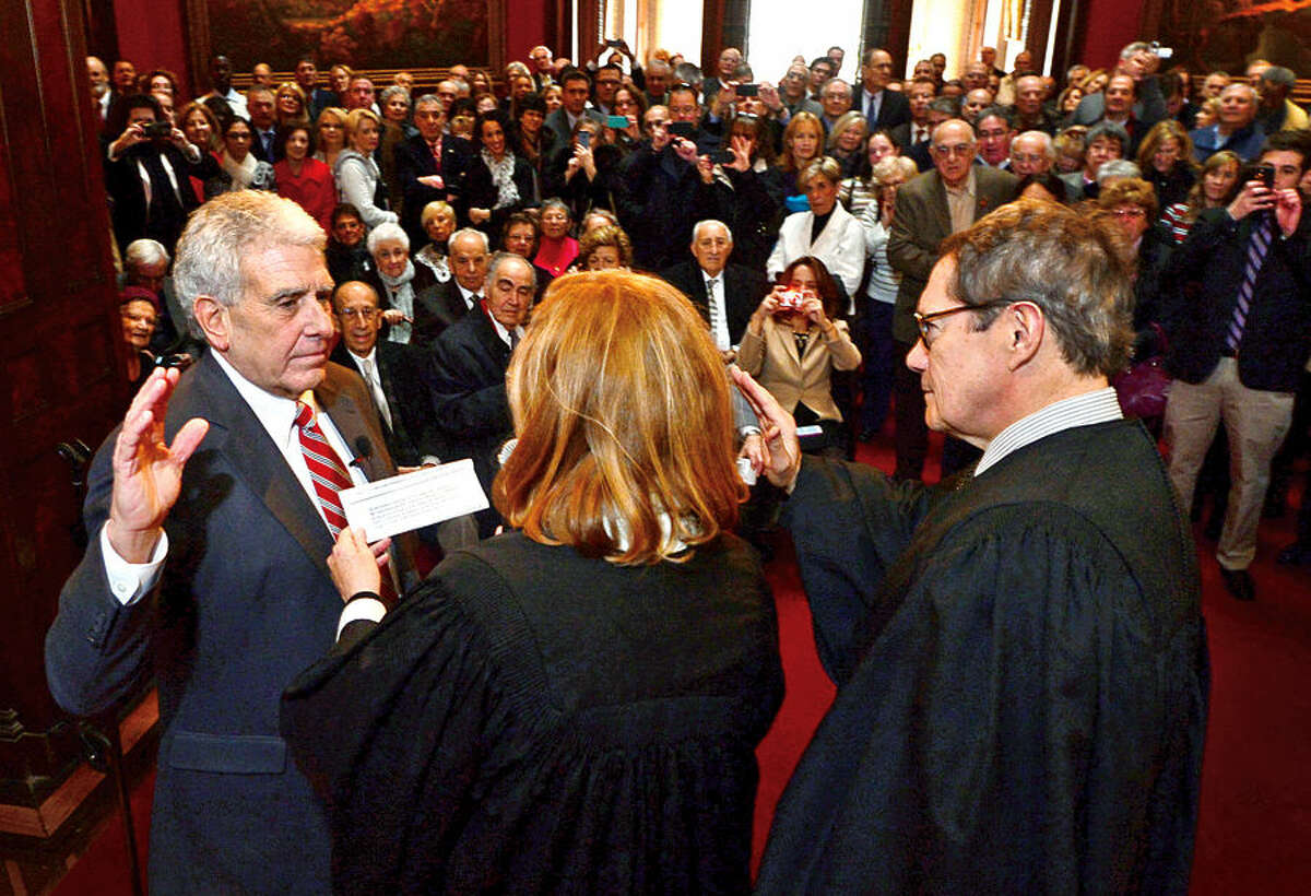 Hour photo / Erik Trautmann Norwalk Judge of Probate Anthony DePanfilis gets sworn in for his last 4 year term by Superior Court Judges Eddie Rodriguez and Maureen Dennis during a ceremony at Lockwood Mathews Mansion Wednesday morning.