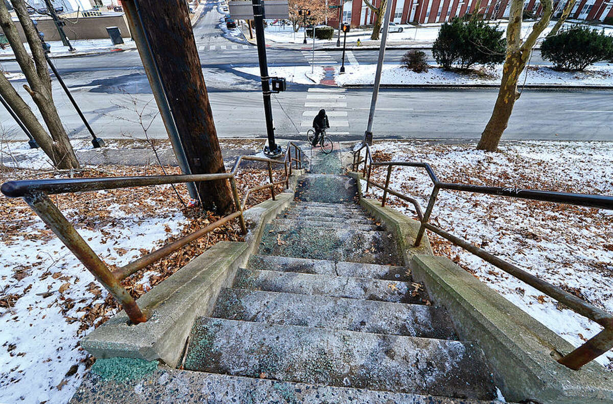 Hour photo / Erik Trautmann Norwalk resident Jimmy Chaguay prepares to take his bicycle up the stairs connecting Martin Luther King Jr. Boulevard and Clay St. Wednesday. The Norwalk Common Council’s Public Works Committee tables an action on approving use of $250,000 of state money to heat and light staircase from Dr. Martin Luther King Jr. Drive to Clay Street.