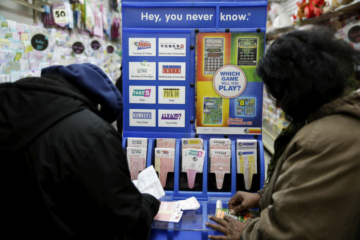 People play various lottery games at a store in New York, Monday, Jan. 11, 2016. Lottery officials say the Powerball jackpot has grown to more than a billion dollars. (AP Photo/Seth Wenig)