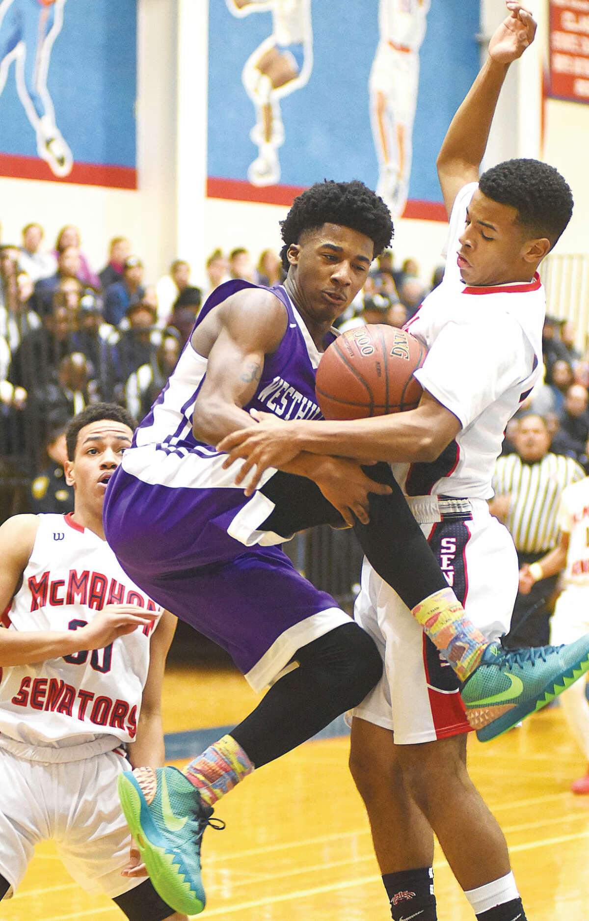 Hour photo/John Nash - Brien McMahon's Marvin Best, right, disrupts the offensive drive of Westhill's Parrish Powell as the Senators' Joe Cantey Jr. looks on during Tuesday's game at Kehoe-King Gym in Norwalk. McMahon moved to 7-0 with a 66-51 win over the Vikings.