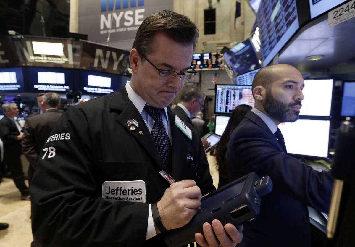 Trader Steven Caro, left, works on the floor of the New York Stock Exchange Monday, Jan. 12, 2015. Stocks are moving lower in early trading, led by a decline in energy stocks as the price of oil fall again. (AP Photo/Richard Drew)