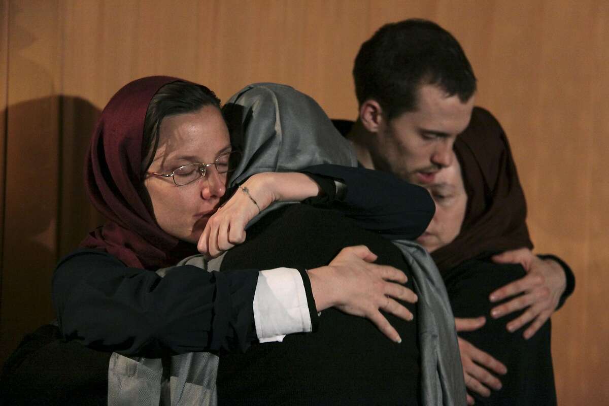FILE - In this May 21, 2010 file photo, Sarah Shourd, left, hugs her mother Nora Shourd, as Shane Bauer, second right, hugs his mother Cindy Hickey, during their meeting at the Esteghlal hotel in Tehran. Iran announced Thursday that one of the three Americans jailed for more than a year will be released Saturday to mark the end of Islamic holy month of Ramadan.