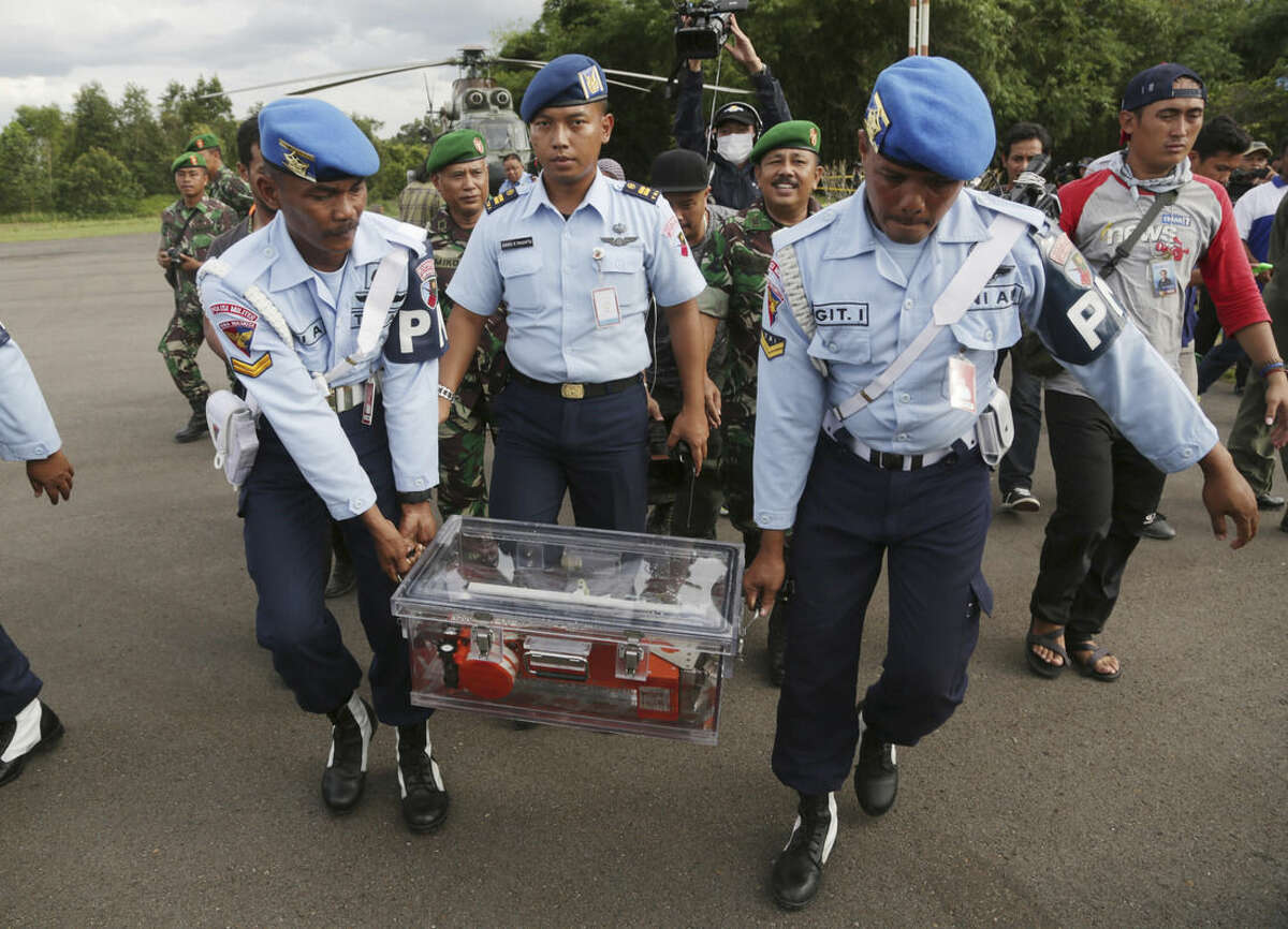 Indonesian air force personnel carry Flight data recorder of the ill-fated AirAsia Flight 8501 that crashed in the Java Sea, at airport in Pangkalan Bun, Indonesia, Monday, Jan. 12, 2015. Divers retrieved one black box Monday and located the other from the AirAsia plane that crashed more than two weeks ago, a key development that should help investigators unravel what caused the aircraft to plummet into the Java Sea. (AP Photo/Achmad Ibrahim)