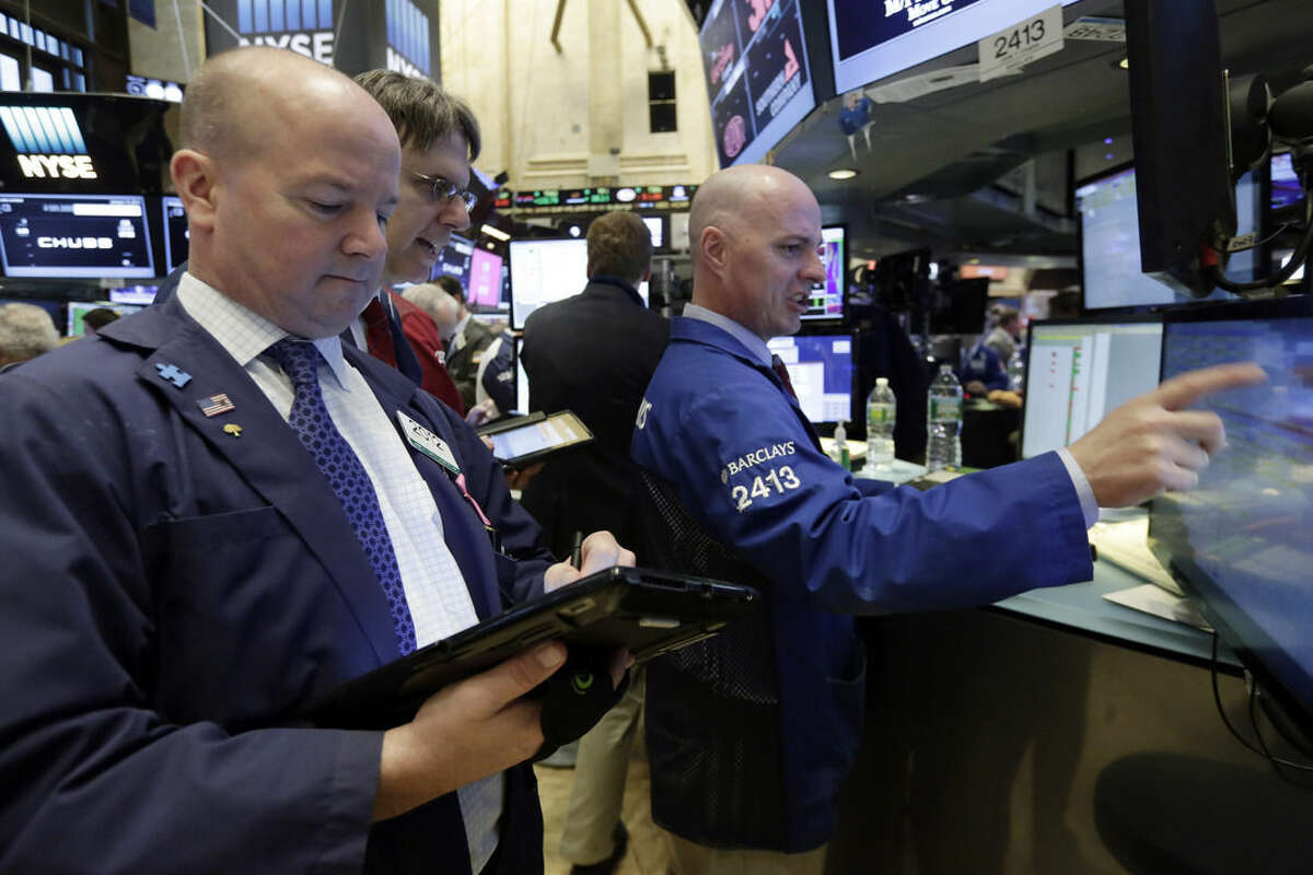 Specialist John O'Hara, right, works with traders on the floor of the New York Stock Exchange, Tuesday, Jan. 19, 2016. U.S. stocks are opening higher, led by gains in banks and technology companies. (AP Photo/Richard Drew)