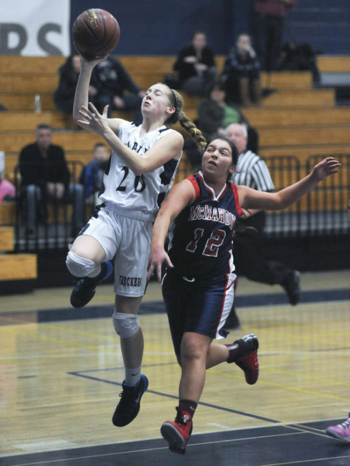 Hour photo/John Nash - Staples' Tessa Mall, left, moves in a lay up as Brien McMahon's Kyle Courtney arrives a little too late to stop her during Thursday's game in Westport.