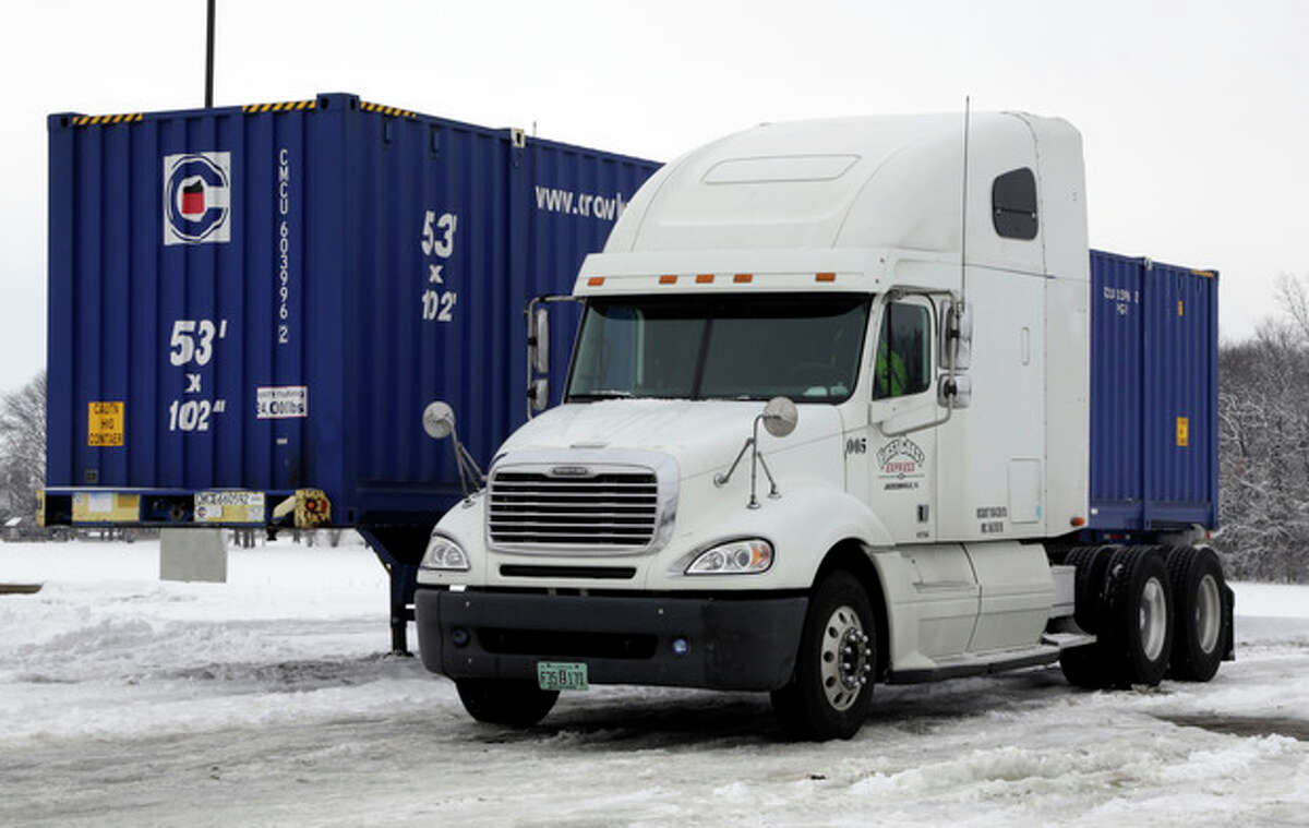 The tractor trailer where Tim Rutledge, 53, of Orlando, Fla., says he crawled under his cab before dawn Monday to fix its frozen brakes when it suddenly settled deeper into the snow, pinning him beneath an axle remains at a truck stop just in Whiteland, Ind., Thursday, Jan. 9, 2014. (AP Photo/Michael Conroy)