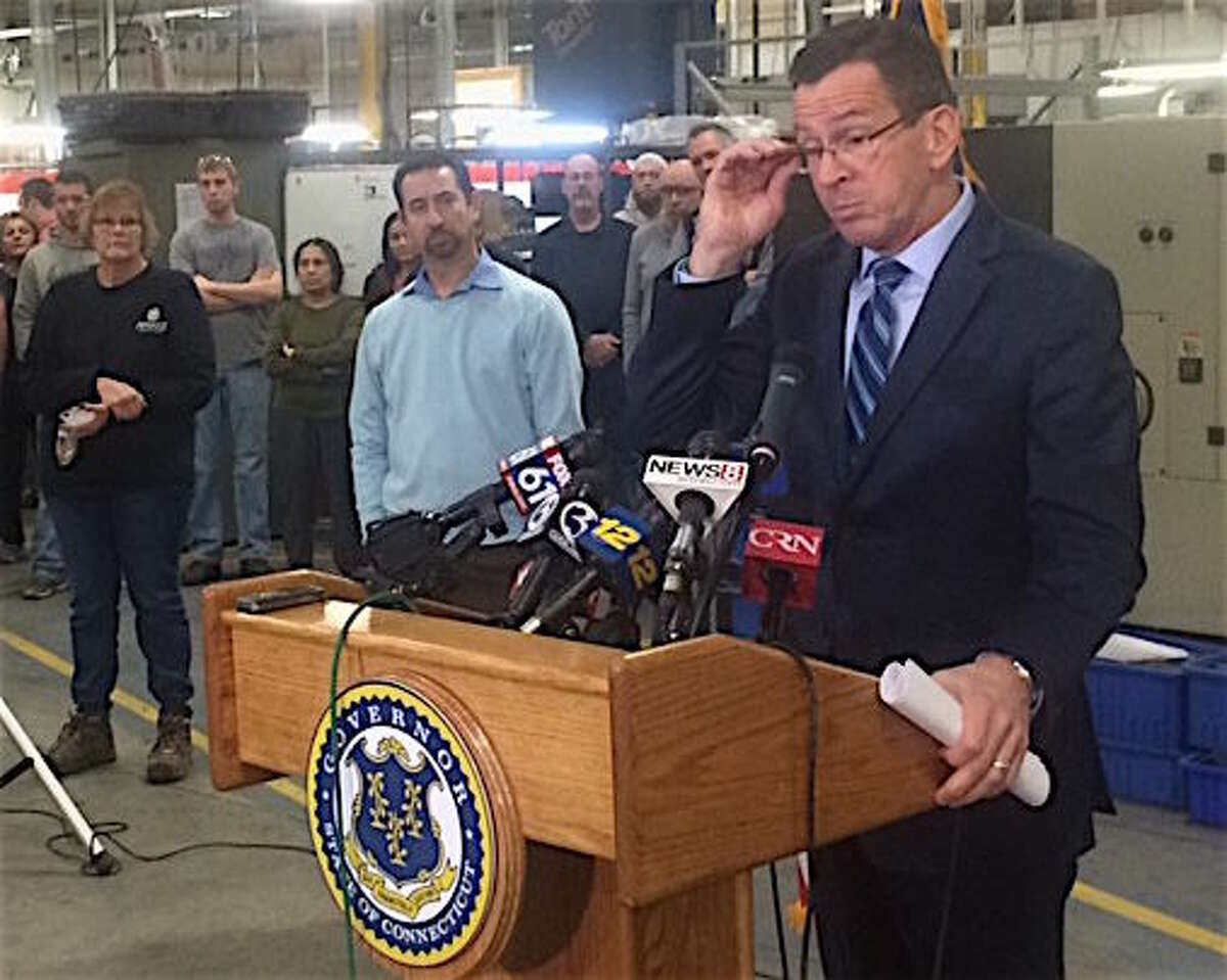 Gov. Dannel P. Malloy takes questions about GE at a hastily arranged appearance at Pegasus Manufacturing in Middletown. At left is the company president, Chris DiPentima.