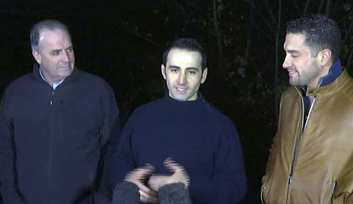 In this image made from video, former U.S Marine Amir Hekmati, center, is flanked by Michigan congressman Dan Kildee, left, and Hekmati's brother-in-law Ramy Kurdi as he speaks to the media in Landstuhl, Germany, Tuesday, Jan. 19, 2016. Former U.S. Marine Amir Hekmati, who was one of four Americans released by Iran as part of a prisoner swap, is in good health and looking forward to getting home soon, a congressman said Tuesday. U.S. Rep. Dan Kildee, a Democrat from Hekmati's home state of Michigan, said he spent several hours with the 32-year-old, who spent 4 ½ years imprisoned in Iran before his release over the weekend. (APTN via AP)