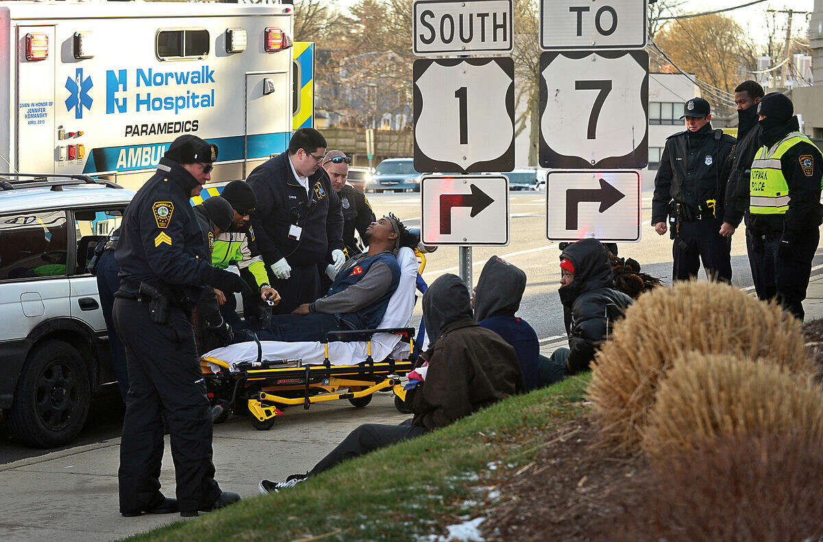 Hour photo / Erik Trautmann Norwalk Paramedics and EMTs transport a young male to Norwalk Hospital after Norwalk police stopped a vehicle on Cross St while investigating an altercation at 41 Wilton Ave. Tuesday afternoon.