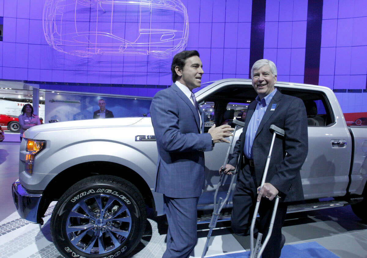 Mark Fields, President and chief Executive Officer of Ford, left, talks with Michigan Gov. Rick Snyder at the Ford exhibit during the North American International Auto Show Tuesday, Jan. 13, 2015, in Detroit. (AP Photo/Detroit Free Press, Diane Weiss) DETROIT NEWS OUT; NO SALES