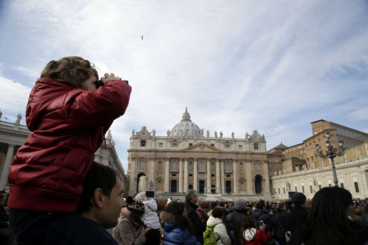 A child uses binoculars to watch Pope Francis delivering the Angelus from a window of the Apostolic palace in St. Peter's Square, at the Vatican, Sunday, Jan. 12, 2014. The pontiff has named his first batch of cardinals, choosing 19 men from Asia, Africa, North and South America and elsewhere, including Haiti and Burkina Faso, to reflect his attention to the poor. Francis made the announcement Sunday as he spoke from his studio window to a crowd in St. Peter's Square. (AP Photo/Gregorio Borgia)