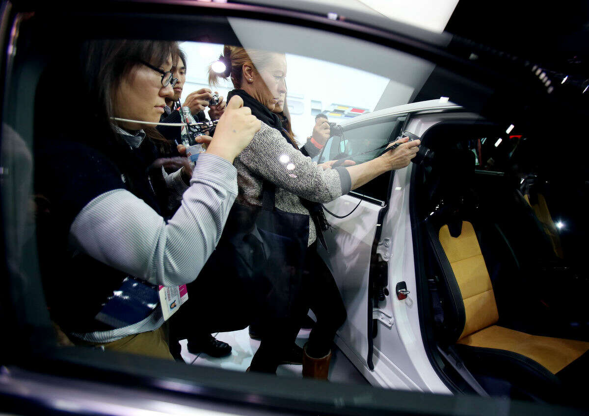Journalists get a look at the 2016 Cadillac CTS-V after it was introduced at the North American International Auto Show on Tuesday, Jan. 13, 2015, in Detroit. (AP Photo/Detroit Free Press, Regina H. Boone) DETROIT NEWS OUT; NO SALES