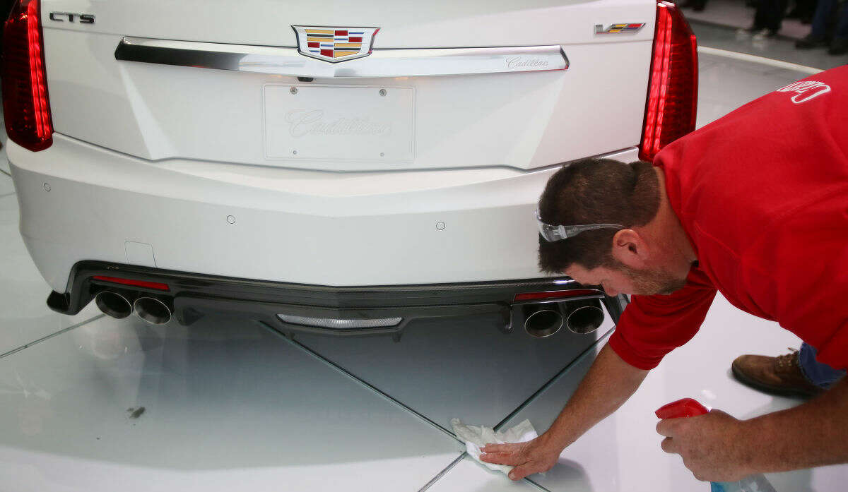 A worker keeps the 2016 Cadillac CTS-V clean after it was introduced at the North American International Auto Show on Tuesday, Jan. 13, 2015, in Detroit. (AP Photo/Detroit Free Press, Regina H. Boone) DETROIT NEWS OUT; NO SALES