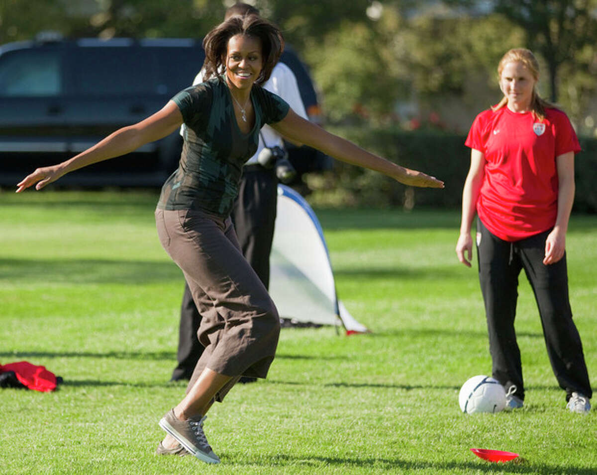 FILE - In this Oct. 6, 2011, file photo, first lady Michelle Obama plays soccer on the South Lawn of the White House in Washington, as part of a Let's Move! clinic. The nation?’s first lady turns 50 on Friday and, by her own account, feels more relaxed now that President Barack Obama?’s days as a candidate for elected office are over. (AP Photo/Evan Vucci)