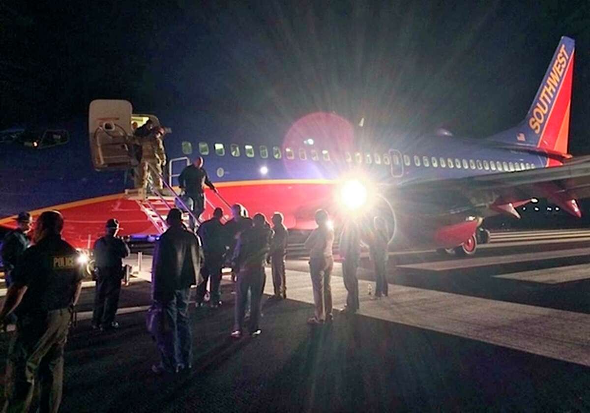 In this Sunday, Jan. 12, 2014 photo provided by Scott Schieffer, passengers exit a Southwest Airlines flight that was supposed to land at Branson Airport in Branson, Mo., but instead landed at Taney County Airport, in Hollister, Mo., that only has about half as much runway. A Southwest spokesman said all 124 passengers and five crew members were safe. (AP Photo/ Scott Schieffer) MANDATORY CREDIT