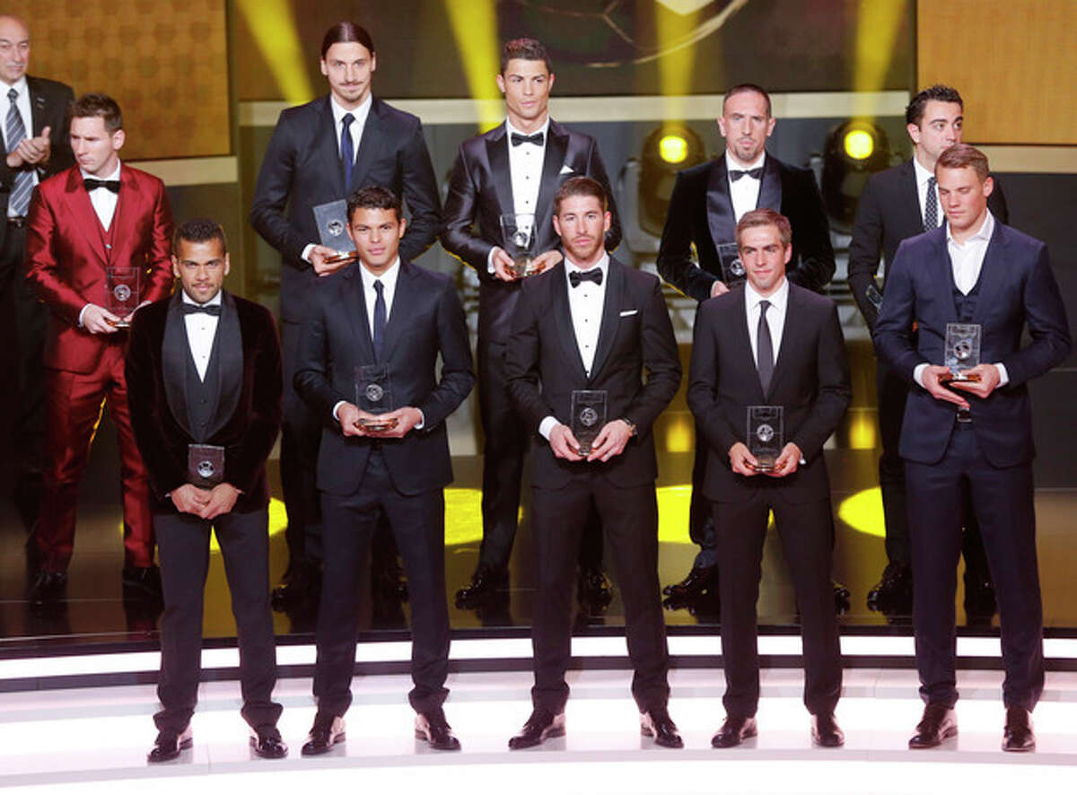 The FIFA "dream team" with the best goal keeper, defenders, midfielders and forwards stands on the stage at the FIFA Ballon d'Or 2013 Gala in Zurich, Switzerland, Monday, Jan. 13, 2014. (AP Photo/Michael Probst) Front row from left: Daniel Alves, Barcelona and Brazil, Thiago Silva, Paris Saint-Germain and Brazil, Sergio Ramos, Real Madrid and Spain, Philipp Lahm, Bayern Munich and Germany, Manuel Neuer, Bayern Munich and Germany, back row from left: Lionel Messi, Barcelona and Argentina, Zlatan Ibrahimovic, Paris Saint-Germain, Cristiano Ronaldo, Real Madrid and Portugal, Franck Ribery, Bayern Munich and Germany and Xavi Hernandez, Barcelona and Spain.