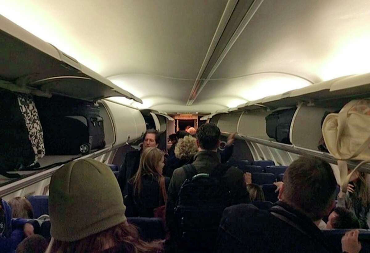 In this Sunday, Jan. 12, 2014 photo provided by Scott Schieffer, passengers gather belongings as they exit a Southwest Airlines flight that was supposed to land at Branson Airport in Branson, Mo., but instead landed at Taney County Airport, in Hollister, Mo., that only has about half as much runway. A Southwest spokesman said all 124 passengers and five crew members were safe. (AP Photo/ Scott Schieffer) MANDATORY CREDIT