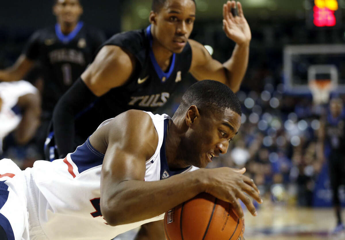 Tulsa's James Woodard, background, watches as Rodney Purvis, of UConn, falls during Tulsa's 66-58 win during an NCAA college basketball game at the Reynolds Center in Tulsa, Okla. on Tuesday, Jan. 13, 2015. (AP Photo/Tulsa World, Cory Young)