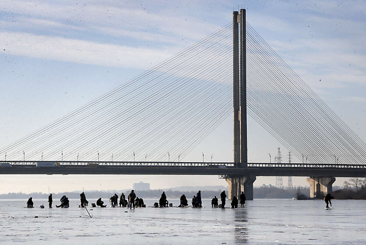 Ukrainians fish in the frozen river Dnipro in Kiev, Ukraine, Wednesday, Jan. 14, 2015. Kiev's temperature on Wednesday dropped to 7 C (44 F). (AP Photo/Efrem Lukatsky)