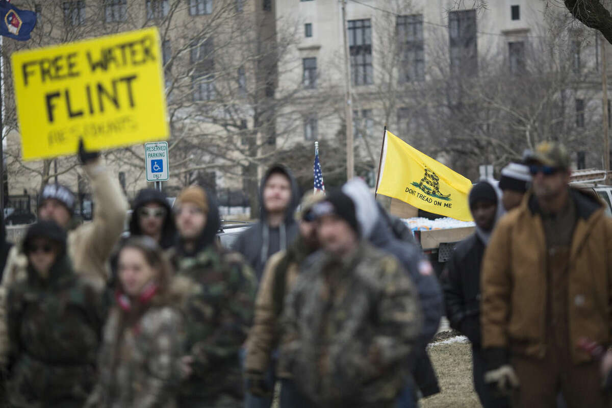 Genesee County Volunteer Militia members and protesters gather for a rally outside of Flint City Hall on Sunday Jan. 24, 2016 over the cities ongoing water crisis. The militia was handing out free bottled water and water filters. (Conor Ralph/The Flint Journal - MLive.com via AP)