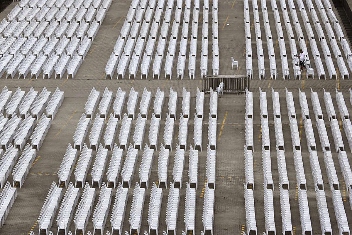 A Filipino worker arranges chairs at a venue for people to meet Pope Francis in suburban Pasay, south of Manila, Philippines on Wednesday, Jan. 14, 2015. Pope Francis arrives Thursday from Sri Lanka for a pastoral visit which is expected to draw millions of faithful where about 81-percent of the population is Catholic. (AP Photo/Aaron Favila)