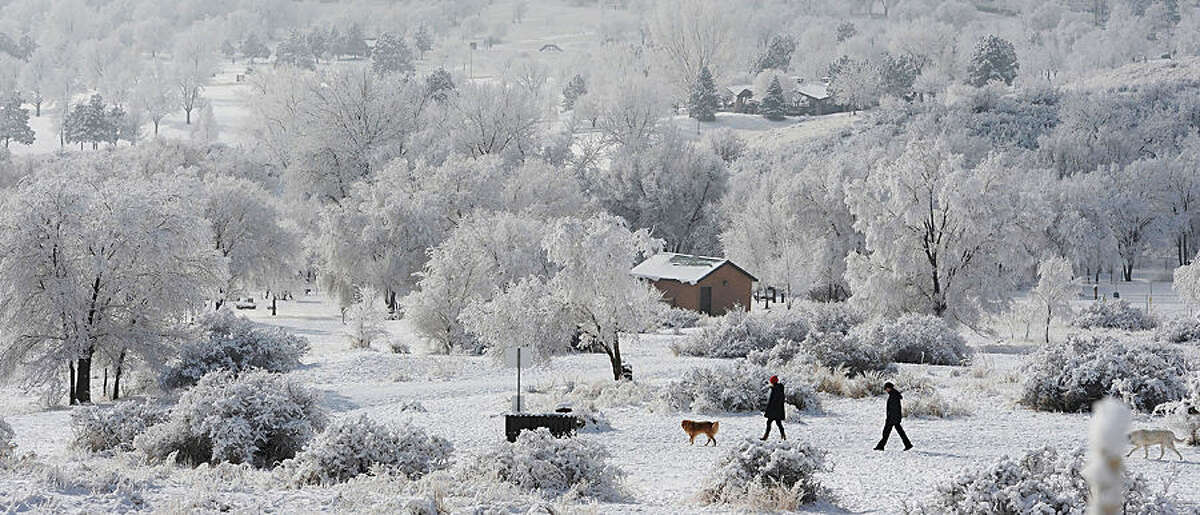 People walk their dogs at Bear Creek Dog Park, Tuesday, Jan. 13, 2015, in Colorado Springs, Colo. (AP Photo/The Gazette, Jerilee Bennett)