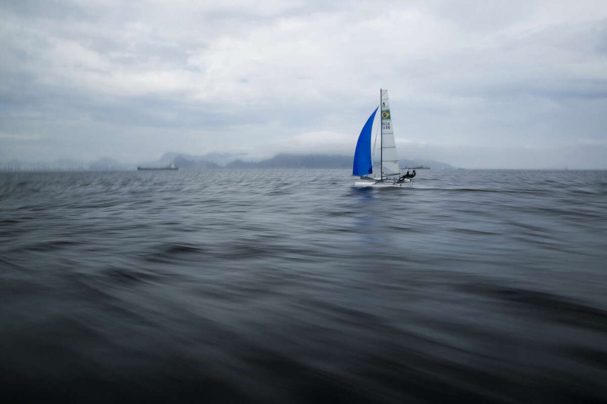 FILE - In this Nov. 3, 2015 file photo, Brazilian athletes Samuel Albrecht and Isabel Swan practice in Guanabara Bay in Rio de Janeiro, Brazil. Independent testing of Guanabara Bay conducted by AP over the last year shows disease-causing viruses linked to human sewage at levels thousands of times above what would be considered alarming in the U.S. or Europe. The tests include the venue for sailing, but also Rio's Olympic venues for rowing, canoeing, open-water swimming and triathlon. (AP Photo/Felipe Dana, File)