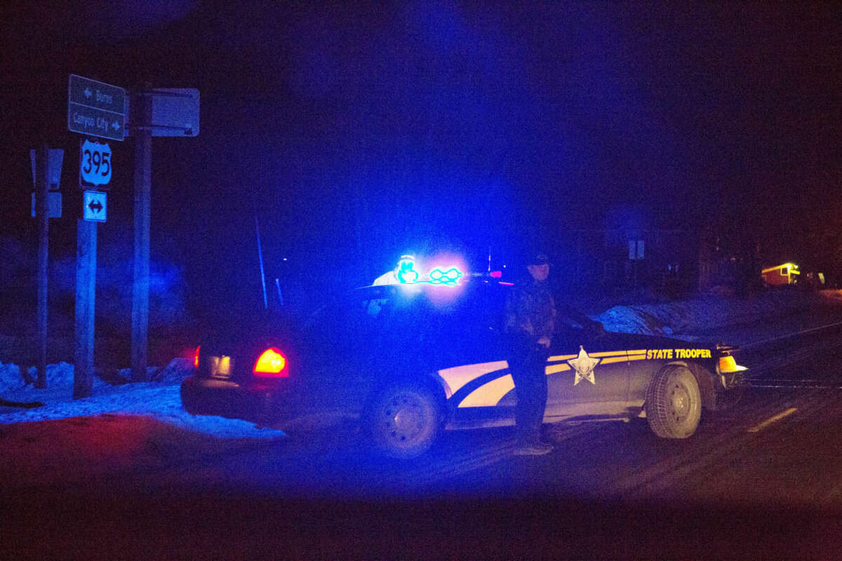 Highway 395 is blocked at Seneca between John Day and Burns, Ore., by Oregon State police officers the evening of Tuesday, Jan. 26, 2016. Authorities say shots were fired during the arrest of members of an armed group that has occupied a national wildlife refuge in Oregon for more than three weeks. The FBI said authorities arrested Ammon Bundy, 40, his brother Ryan Bundy, 43, Brian Cavalier, 44, Shawna Cox, 59, and Ryan Payne, 32, during a traffic stop on U.S. Highway 395 Tuesday afternoon. In a statement Tuesday, the FBI said one individual “who was a subject of a federal probable cause arrest is deceased.” (Dave Killen/The Oregonian via AP) MAGS OUT; TV OUT; NO LOCAL INTERNET; THE MERCURY OUT; WILLAMETTE WEEK OUT; PAMPLIN MEDIA GROUP OUT; MANDATORY CREDIT