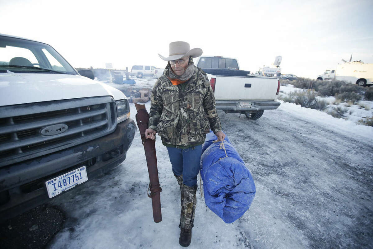 FILE - In this Jan. 6, 2016 file photo, Arizona rancher LaVoy Finicum carries his rifle after standing guard all night at the Malheur National Wildlife Refuge near Burns, Ore. The FBI and Oregon State Police arrested the leaders of an armed group that has occupied a national wildlife refuge for the past three weeks during a traffic stop that prompted gunfire, and one death, along a highway through the frozen high country. The Oregonian reported that Finicum was the person killed, citing the man's daughter. (AP photo/Rick Bowmer)