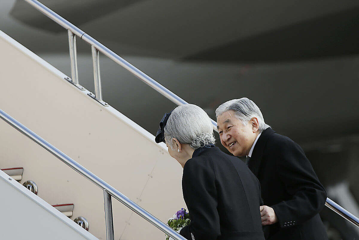 Japan's Emperor Akihito smiles at Empress Michiko as they board their airplane to leave for the Philippines at Haneda International Airport in Tokyo, Tuesday, Jan. 26, 2016. Akihito and Michiko left for a trip to the Philippines that suffered under Japanese occupation during World War II. (AP Photo/Eugene Hoshiko)