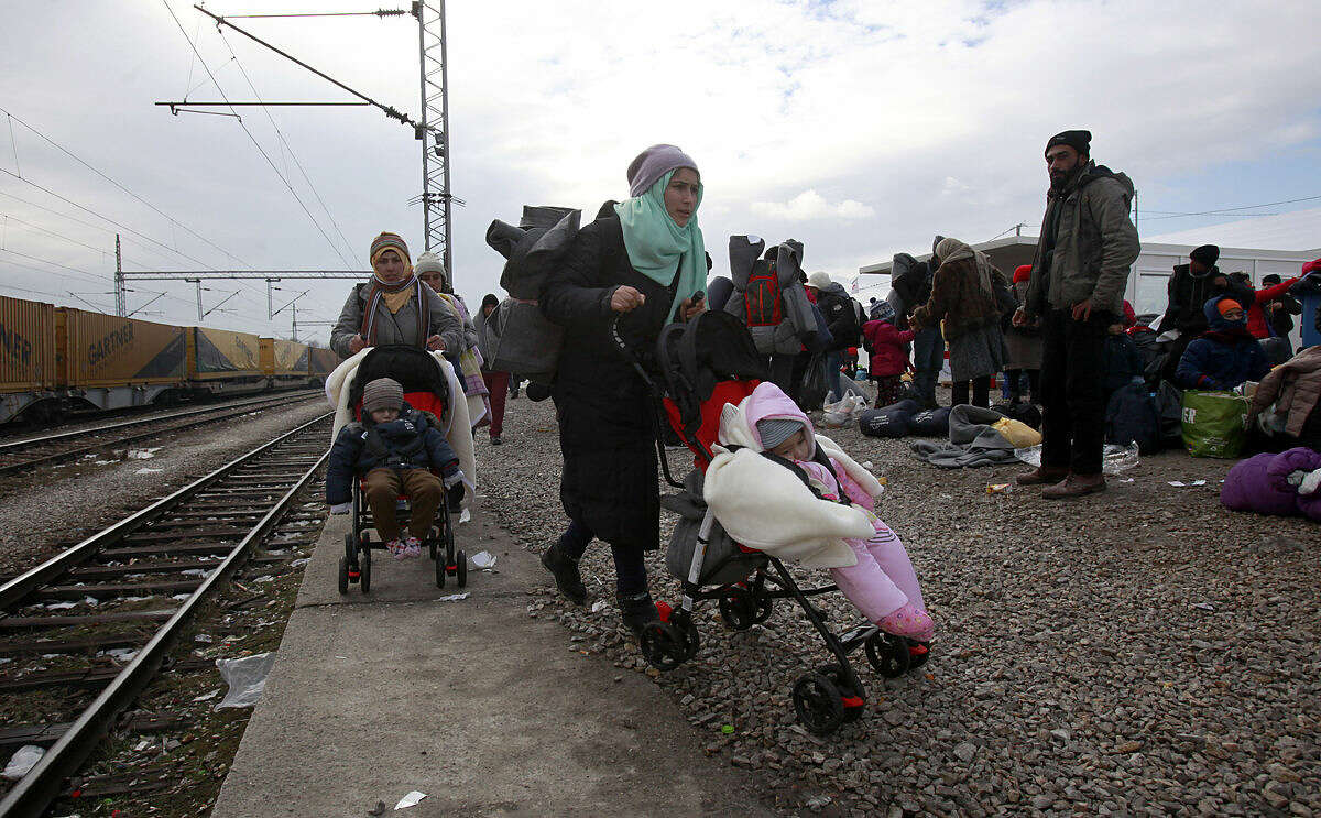Refugees push their children in strollers as they continue their journey to Serbia from the transit center for refugees near northern Macedonian village of Tabanovce, Tuesday, Jan. 26, 2016. European Union nations took a step Monday toward isolating Greece amid acrimony over Athens' failure to stem the flow of migrants at its Mediterranean island borders. The member states "gave a clear signal" that if they can't stop the migrants reaching Greece, they would consider helping Greece's neighbor Macedonia to better seal its border to slow the movement of migrants into other European countries. (AP Photo/Boris Grdanoski)