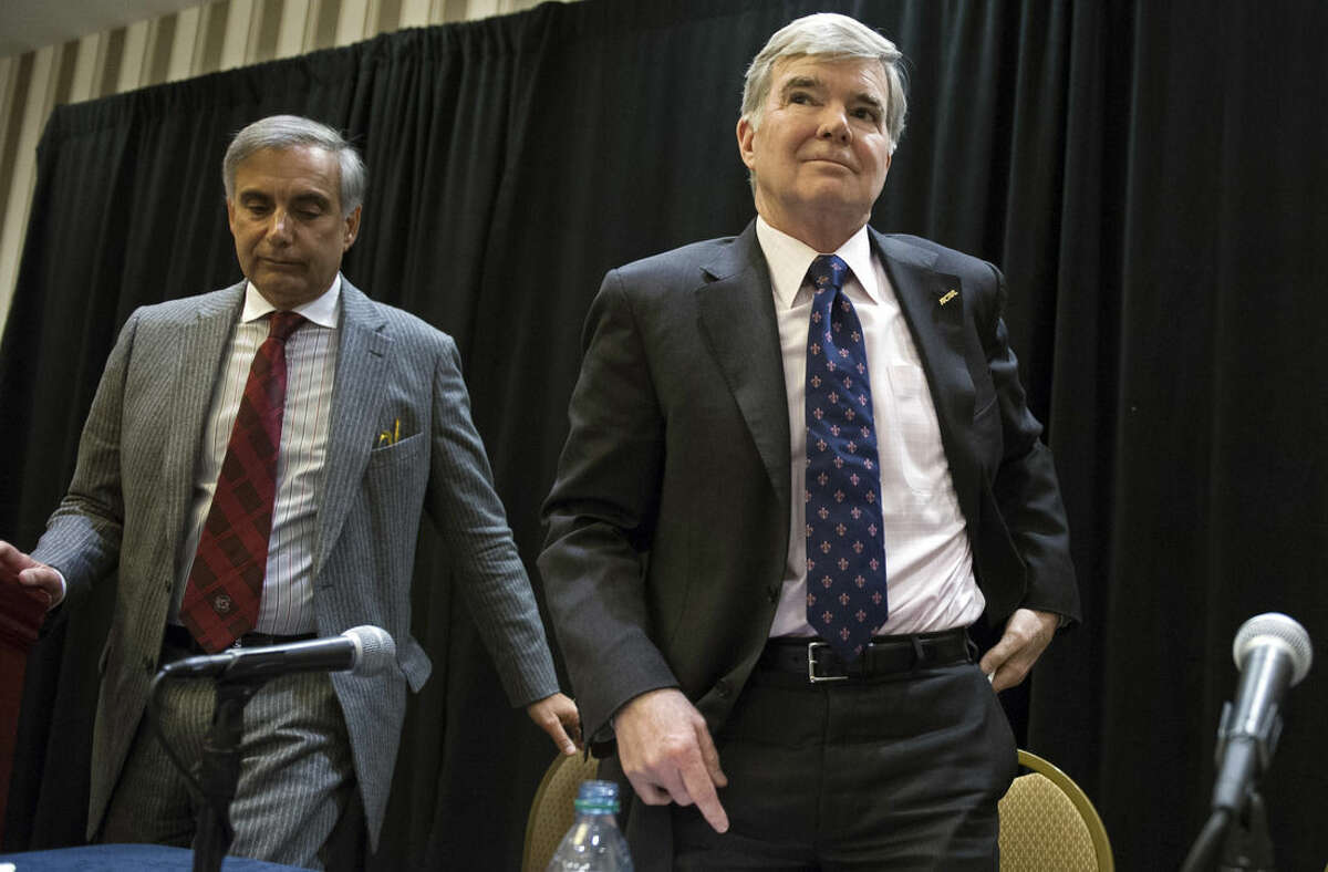 Division 1 board of directors member Harris Pastides, left, University of South Carolina president, and NCAA President Mark Emmert depart a news conference at the NCAA Convention in Oxon Hill, Md., Friday, Jan. 16, 2015. The NCAA announced Friday, a settlement with Penn State that will give the school back 112 wins wiped out during the Jerry Sandusky child molestation scandal and restore the late Joe Paterno as the winningest coach in major college football history. (AP Photo/Cliff Owen)