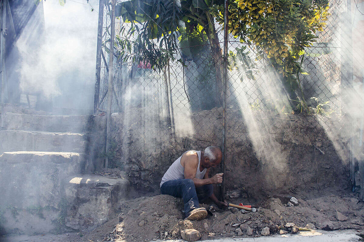 A man works on a fence amidst a cloud of insecticide as city workers fumigate to combat the Aedes Aegypti mosquitoes that transmits the Zika virus, at the San Judas Community in San Salvador, El Salvador, Tuesday, Jan. 26, 2016. Worries about the rapid spread of Zika through the hemisphere has prompted officials in El Salvador, Colombia and Brazil to suggest women stop getting pregnant until the crisis has passed. (AP Photo/Salvador Melendez)