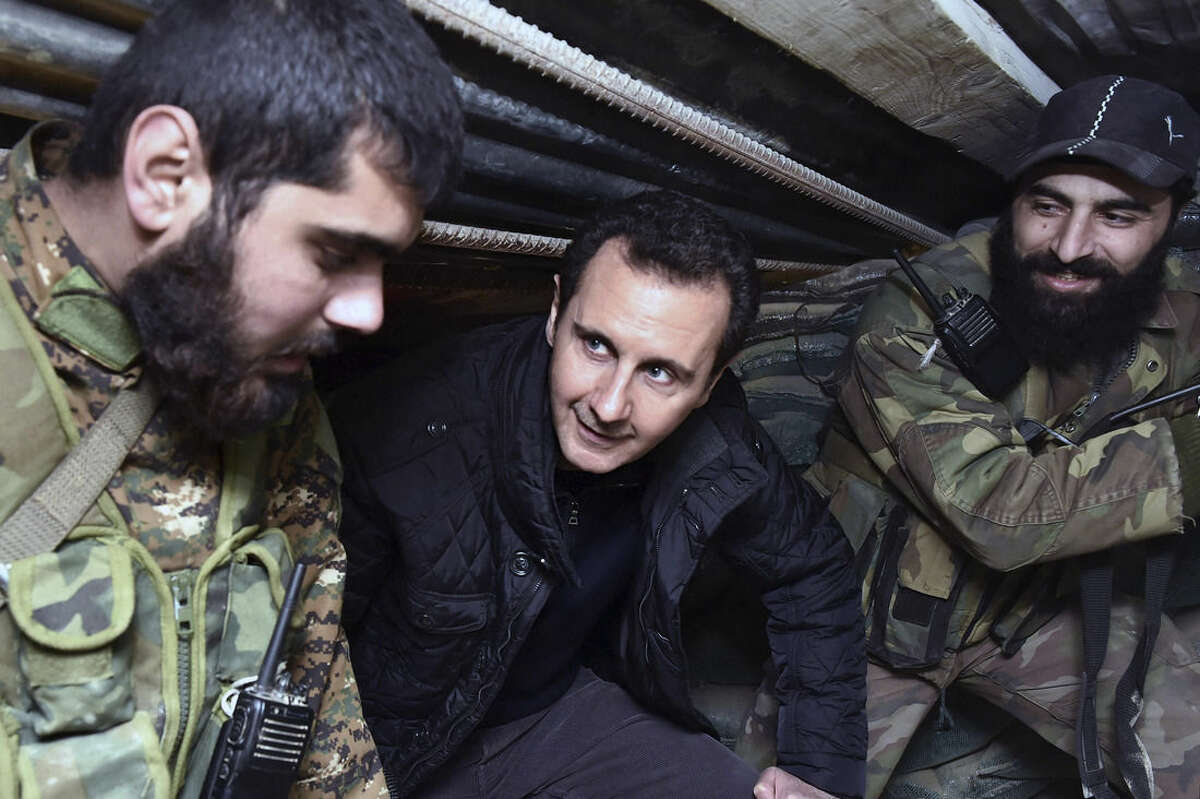 FILE -- In this Wednesday, Dec. 31, 2014, file photo released by the Syrian official news agency SANA, Syrian President Bashar Assad, center, speaks with Syrian troops during his visit to the front line in the eastern Damascus district of Jobar, Syria. A Russian initiative to host peace talks this month between the Syrian government and its opponents appears to be unraveling, as prominent Syrian opposition figures shun the planned negotiations over concerns that the framework is flawed and holds little chance of success. (AP Photo/SANA, File)