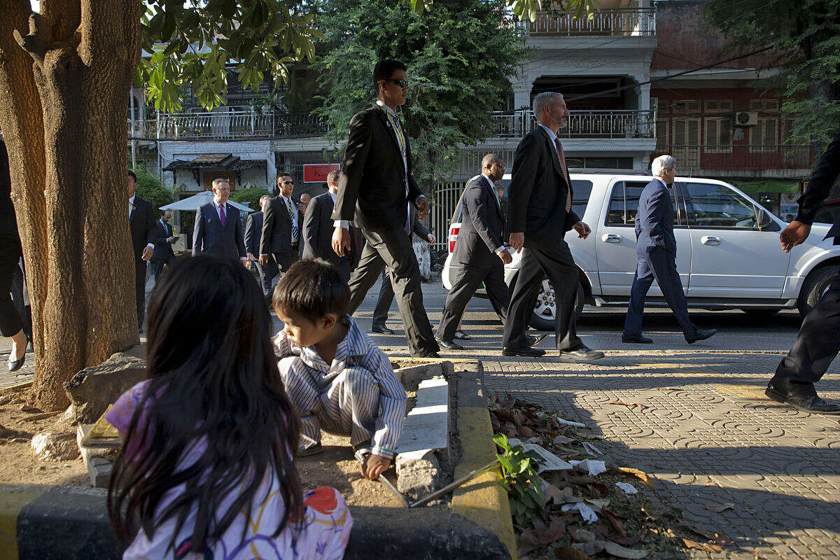 Children play on Street 240 as U.S. Secretary of State John Kerry, right, walks by while souvenir shopping in Phnom Penh, Cambodia, Tuesday, Jan. 26, 2016. Kerry is in Cambodia on the fourth leg of his latest round-the-world diplomatic mission, which will also take him to China. (AP Photo/Jacquelyn Martin, Pool)