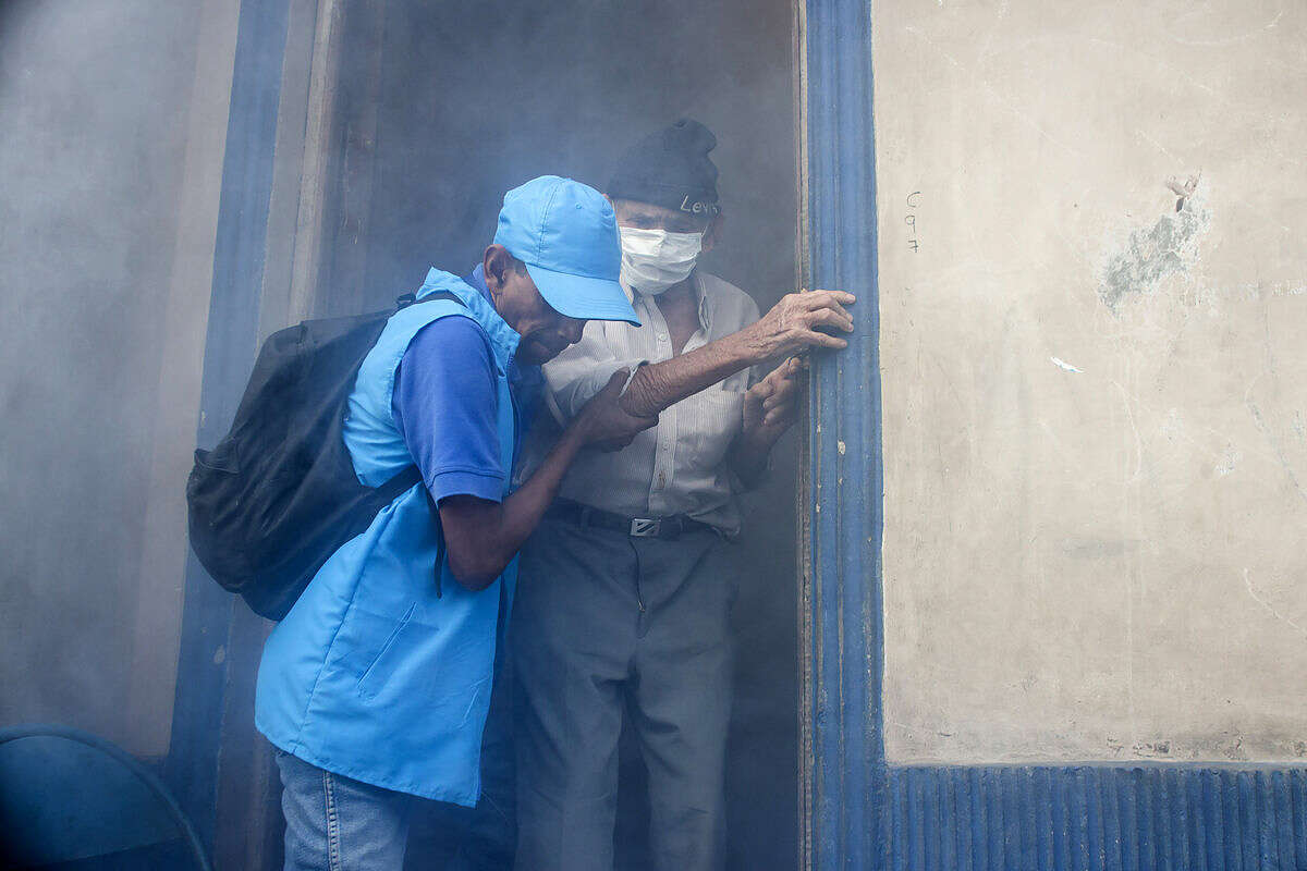 A city worker helps homebound Simon Jose Valentin, 94, leave his home while it is fumigated to combat the Aedes Aegypti mosquitoes that transmit the Zika virus, at the San Judas Community in San Salvador, El Salvador, Tuesday, Jan. 26, 2016. Worries about the rapid spread of Zika through the hemisphere has prompted officials in El Salvador, Colombia and Brazil to suggest women stop getting pregnant until the crisis has passed. (AP Photo/Salvador Melendez)
