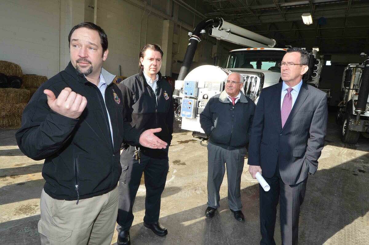 Tyler Theder, regulatory compliance and administrative officer with the city of Stamford’s Office of Operations, talks with Gov. Dannel P. Malloy, Ernie Orgera, the city’s director of operations and Thomas Turk, transportation and road maintenance supervisor, about two new vehicles the city recently purchased: A vactor truck, used to clean catch basins, and a CCTV camera truck, which provides live video feeds from underground pipes and basins.