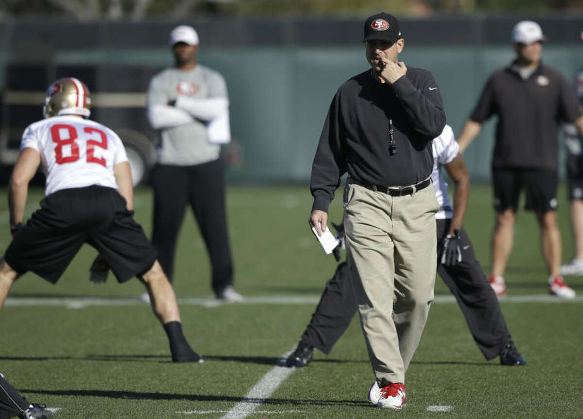 San Francisco 49ers coach Jim Harbaugh, right, walks on the field prior to an NFL football practice in Santa Clara, Calif., Friday, Jan. 17, 2014. The 49ers are scheduled to play the Seattle Seahawks for the NFC championship Sunday. (AP Photo/Ben Margot)